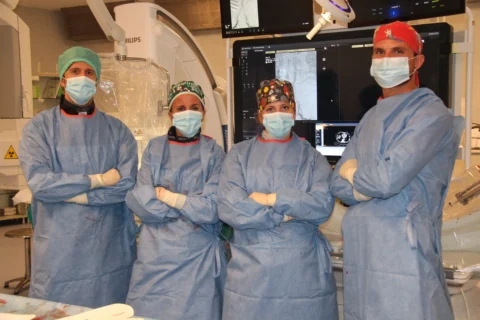 Inserimento dell'endoprotesi EVAR in sala operatoria Discussione del team medico in sala operatoria durante procedura EVAR