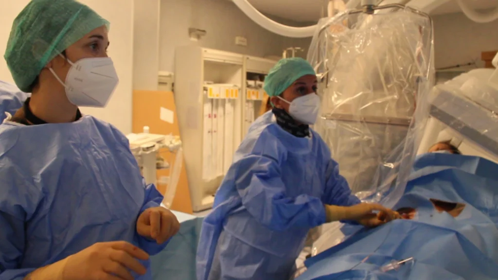 Medico in sala operatoria esegue embolizzazione sotto guida radiologica per il trattamento di tumori.